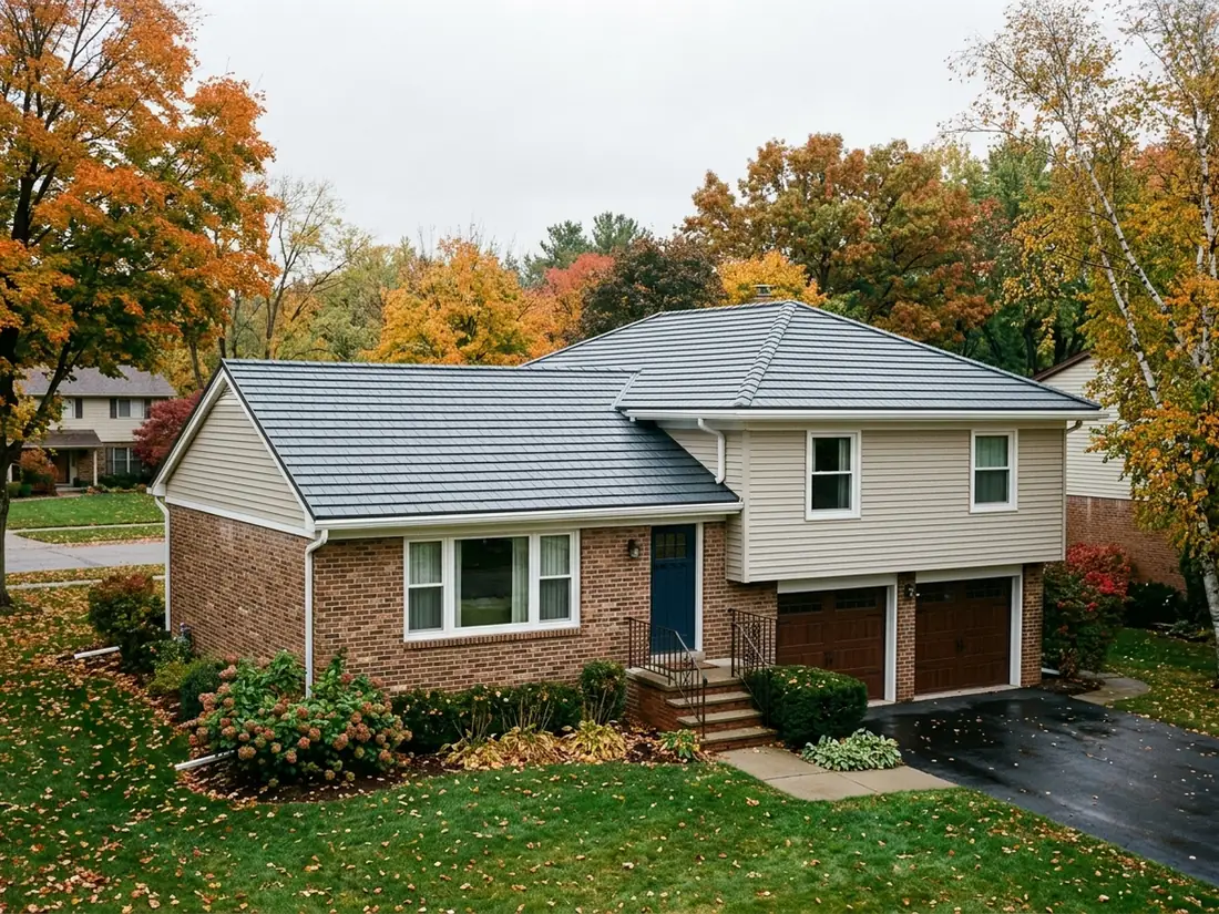 Split-level brick and siding house with a slate-grey steel shingle roof and white gutters